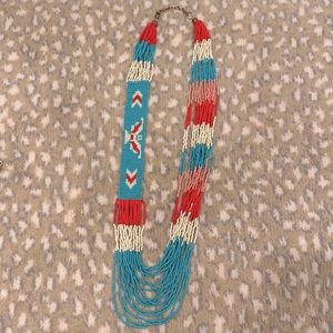 Hand-made, multi strand long beaded necklace with bird/tribal design.